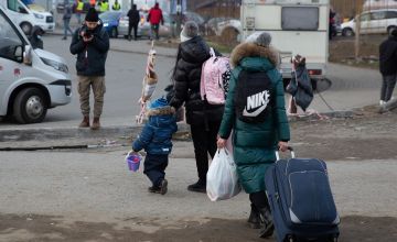 Child holding parent's hand at Polish border