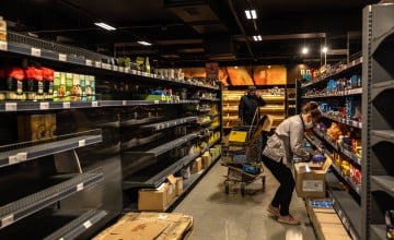 Supermarket staff stocking empty shelves