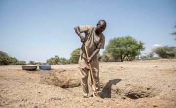 Joseph fetches water from a hand-dug well that his community is currently relying on in Northern Kenya