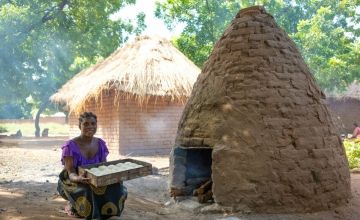 Gladys Peter, 23, using the oven where she makes scones for her family's tearoom that was opened with support from Concern.