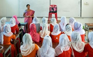 A group of school girls being taught about menstrual hygiene by a Concern staff member.