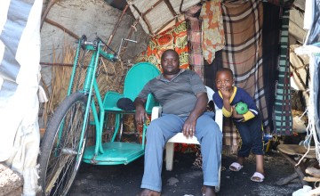 Akilimali Nzabonimpa Emmanuel, 37, with one of his four children in the Bulengo Site, DRC.