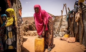 Ayaan collects water in a jerry can 