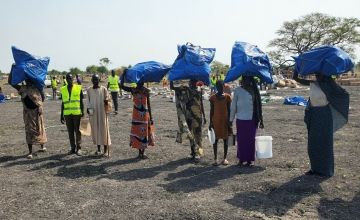 Concern staff distributing essential items such as plastic sheeting, blankets, mosquito nets, sleeping mats, cooking sets, solar lamps and ropes to people arriving from Sudan, in Rotriak settlement, Unity State, South Sudan. Photo: Abdul Ghaffar/Concern Worldwide