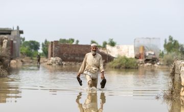Man walking through floodwater in Pakistan