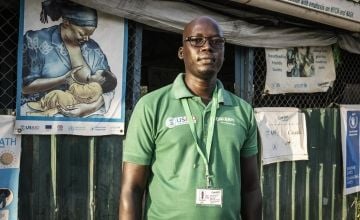 William Bol Ngudeng, Concern Nutrition Project Officer, stands outside a health care centre in Bentiu IDP Camp.