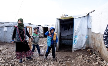 Fatima pictured with Nahed* (9) and Malak* (9) in their waterlogged camp.