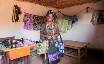 Alexia is proud of the brightly coloured fabric bags she has carefully and expertly made, after starting up a successful tailoring business in a small workshop in her village.