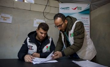 Muhammed (38) works with his colleague Hussein inside the center distributing cash vouchers to beneficiaries of those affected by the February 6th 2023 earthquake. Photo: Ali Haj Suleiman/DEC/Fairpicture