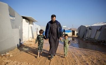 Jaafar* (32) walks with his children on the muddy roads of the Ahl al-Khair camp, which was established after the February 6th 2023 earthquake.