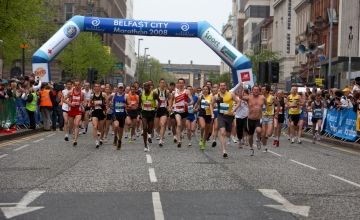 Group of diverse runners participating in the Belfast City Marathon 2008, with the starting inflatable arch visible in the background.