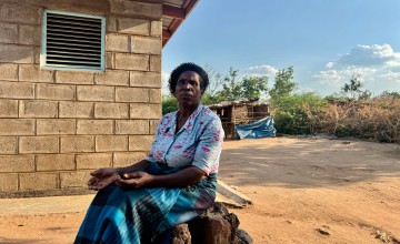 Sige, sitting in front of her home in Bitilinyu camp