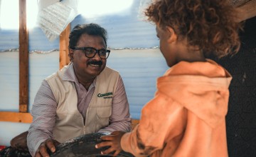 Concern Yemen Country Director Victor Moses chats to a child in  in Yemen. The effects of conflict in Yemen has triggered a hunger crisis causing 5 million children under the age of five in need of treatment for acute malnutrition. Photo: Ammar Khalaf/Concern Worldwide