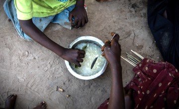 Eric Kyugu and his wife, Mado share breakfast with their children in the village of Pension, Manono Territory. Photo: Hugh Kinsella Cunningham/Concern Worldwide
