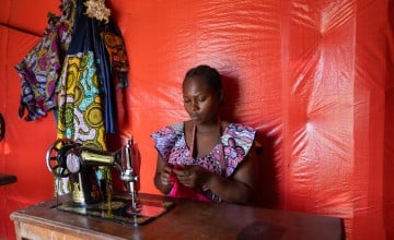 Alice works on a garment in her tailoring shop in Mangothe, DRC. After fleeing conflict, she built a successful business and now trains other women in dressmaking skills. Through a Concern-supported VSLA group, she has expanded her enterprise and owns five sewing machines. Photo: Eugene Ikua/Concern Worldwide
