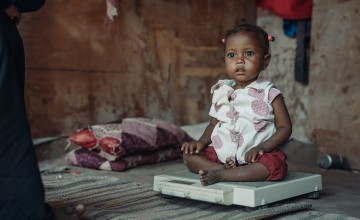 Fatima* getting ready for a weight check by Basma at her shelter in one of the displacement camps in Lahj Governorate, Yemen. Photo: Concern Worldwide.