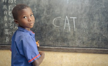 A student in class 1 at Benevolent Islamic Primary School in Makinth community writes on the black board, Tonkolili, Sierra Leone. Photo: Michael Duff.