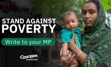 A mother in a green headscarf holds her baby. Text reads Stand Against Poverty. Write to your MP.