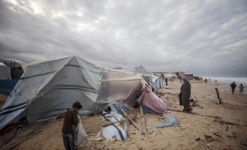 Boy stands outside a tent in Gaza