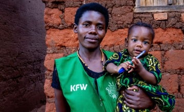 A mother with her baby in her arms.