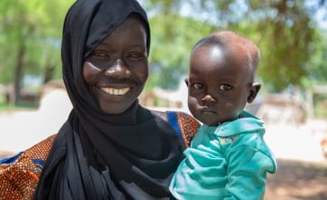 A mum and her 18-month-old son outside a health centre in South Sudan