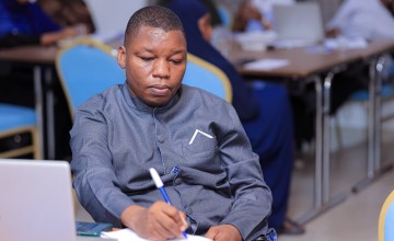 A man writing on paper at a desk