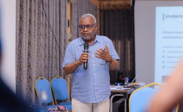 A man talking into a microphone at a conference.