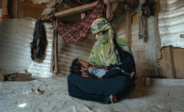 A mother cradles her young son in a displacement camp in Yemen