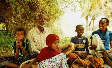 A man sits with four of his children around him