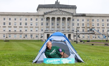 A man in a tent pitched in front of Stormont Buildings in Belfast