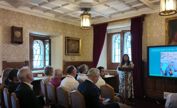 Sayyeda stands in front of a crowd of people