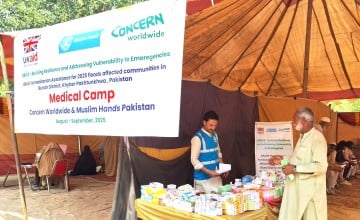 An aid worker provide essential supplies to a man in Pakistan