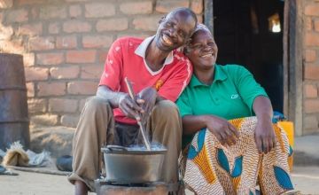 Chibala, 55, cooks at his home in May 2014 in Zambia with his wife Catherine, 43, sat next to him. Photo: Gareth Bentley / Concern Worldwide. 