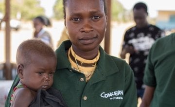 Chan Adim Garang, is one of twins admitted to the outpatient therapeutic programme (OTP) run by Concern in Maduany in Aweil North, South Sudan. Pictured here with Monica Mawien a supervisor with the Concern community nutrition team. Photographer: Kieran M