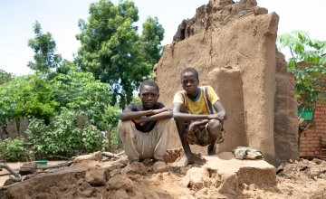 Brothers, Charity(16) and Fraction (14) standing on what's left of their home. Their home was washed away with all their belongings. The brothers family are casual labourers. With no crops to harvest, his parent won't have any work this season.  Location: