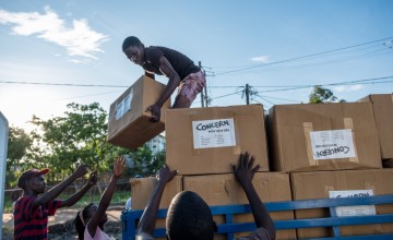 Esparanza Maria, a 25-year-old day worker from Nhamatanda, helps load boxes containing essential household supplies from a warehouse to a truck. The items will be distributed the next day in the village of Ndeja. "It makes me feel good to be able to help 