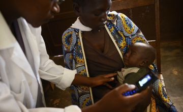 Nurse Orene Nahimana measures three-month-old Roger’s rate of breathing to diagnose if he has pneumonia. His mother brought him to Burara Health Centre after receiving advice from a Concern-supported community health worker. Photo: Chris de Bode