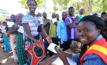 Triphonia Jonathan, (30) receiving a cash transfer from Nuciana Njolomola, 45 an agent used by Concern Worldwide, Chazuka Village, Mchinji, Malawi Photo by Jennifer Nolan.