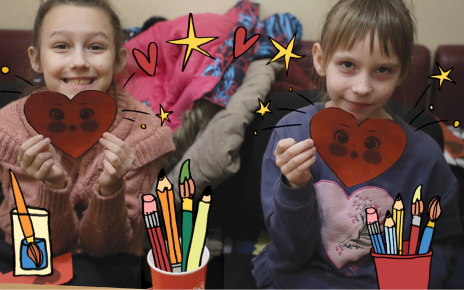 Two smiling girls hold handmade red paper hearts, surrounded by illustrated art supplies, hearts and stars.