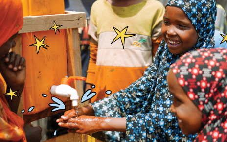 A smiling girl washes her hands under a water tap while other children gather around, with illustrated water splashes and stars.