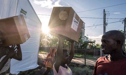 Esparanza Maria, a 25-year-old day worker from Nhamatanda, helps load boxes containing essential household supplies from a warehouse to a truck. Mozambique. Photo: Tommy Trechard 