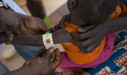A health worker at a Concern-supported clinic at Gbadengue carries out a regular health assessment of 17-month-old Nicoles. She was diagnosed as severely malnourished two weeks ago. Since then, she has put on more than half a kilo. Photographer: Chris de Bode
