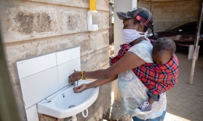 Margret with baby Charlyne, using a hand washing station in Kiberia. Photo: Ed Ram / Concern Worldwide