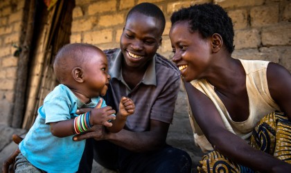 Eric Kyugu and Mado Kabulo, a married couple play with their 7-month-old baby Bienheureux in the village of Pension, Manono Territory.