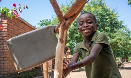 Chabuka James (10) using a tippy tap that his family was taught to build from Concern Worldwide. Photo: Chris Gagnon