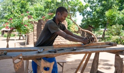 Jusa James working on his carpentry equipment. Photo: Chris Gagnon/Concern Worldwide