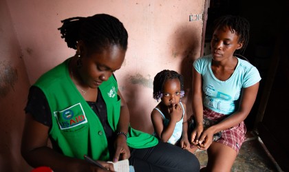 Michaelle Appolon of Concern Worldwide in Haiti interviews Felicie Jeune and her daughter Celise Jean Baptiste at their home in Cité Soleil, Port-au-Prince. The family participates in the USAID-funded Manje Pi Byen program. Photo: Kieran McConville/Concern Worldwide