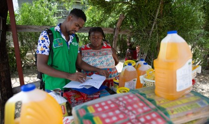 Concern's Sadrac Antoine with Justa Ernice, a small trader in the Cité Soleil area of Port-au-Prince, Haiti who has worked with Concern to develop her business. She is now a registered vendor for the USAID-funded Manje Pi Byan program. Photo: Kieran McConville/Concern Worldwide