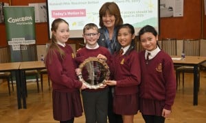 Students in red uniforms stand in Stormont holding awards