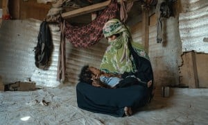 A mother cradles her young son in a displacement camp in Yemen